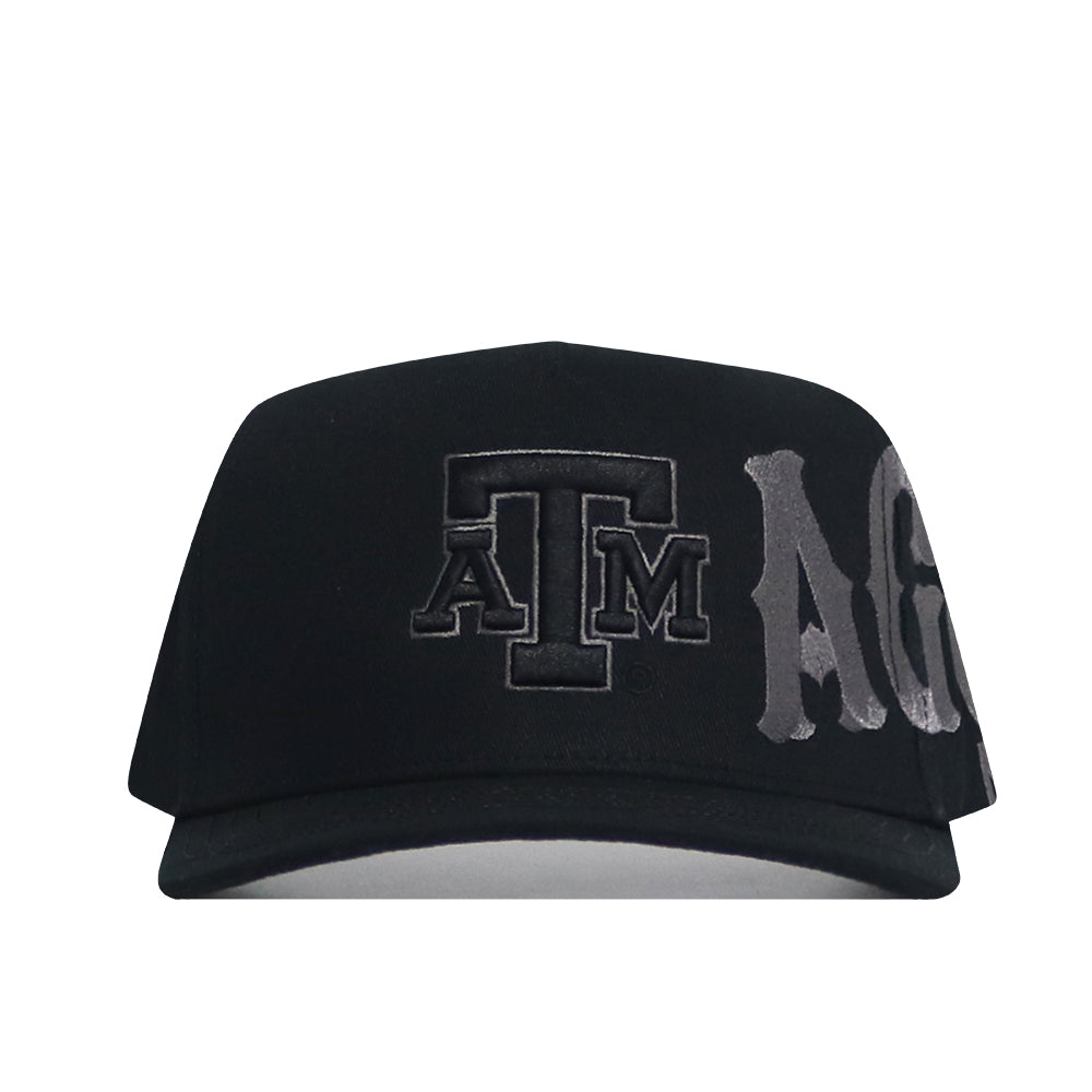 The No Rivals Texas A&M Night Mode Hat is a black high crown cap with the ATM logo in dark lettering on the front and "Aggies" partially spelled out in bold silver letters beside it.