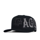 The Texas A&M Night Mode Hat by No Rivals is a black snapback with a high crown and structured fit, featuring bold gray ATM AGG embroidery on the front and side for Aggies fans.