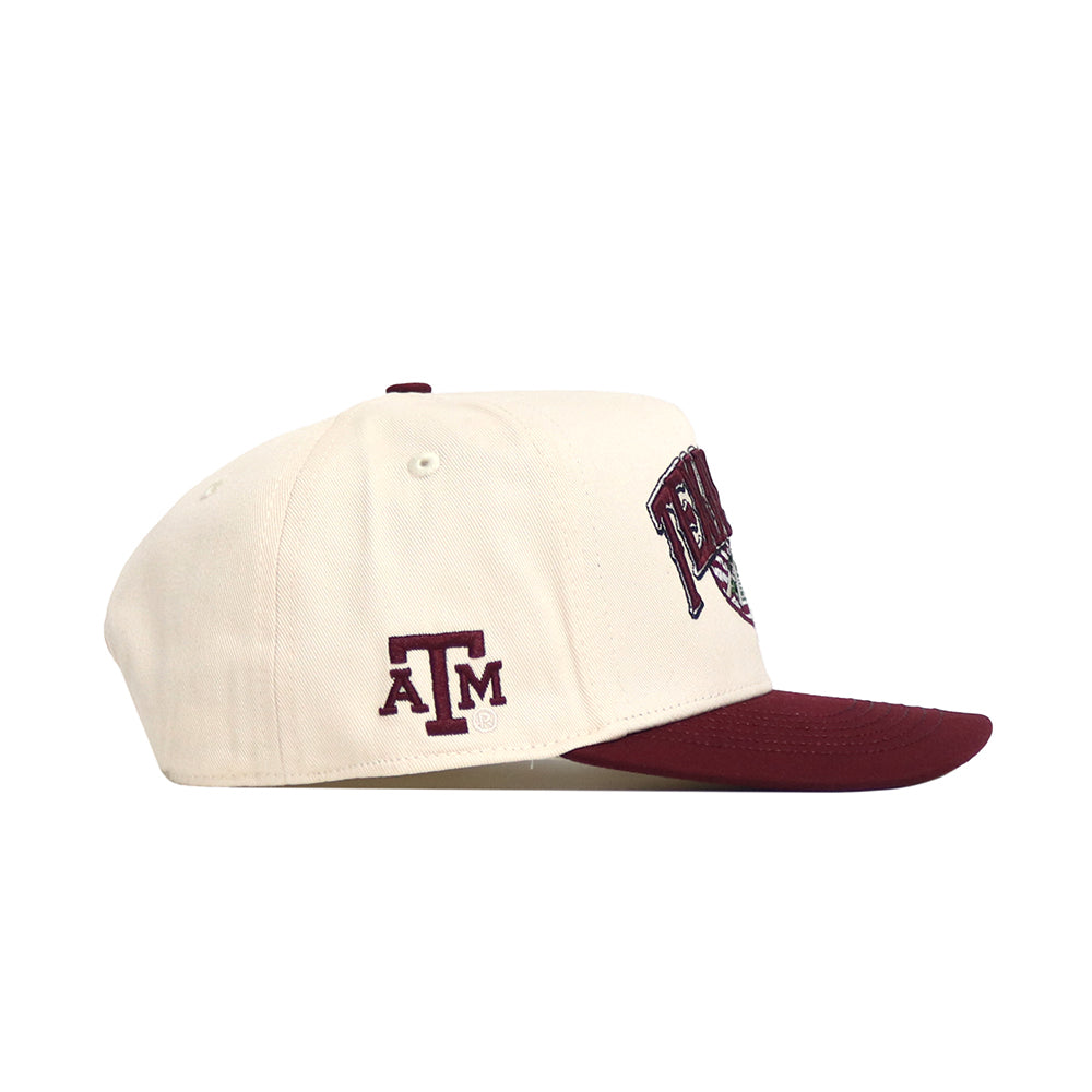 The Texas A&M Stadium Hat by No Rivals is a structured white snapback with a maroon brim, Texas A&M ATM logo on the side, and partial maroon and black embroidery on the front.