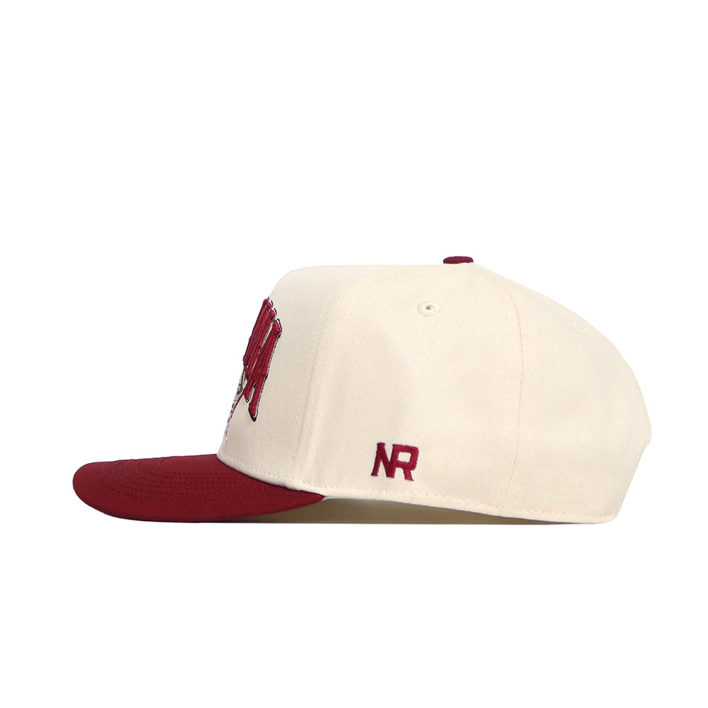 The Alabama Stadium Hat by No Rivals is a cream snapback with a maroon brim and button, featuring "NR" embroidered in maroon on the side. Made from high quality cotton, it's pictured in side profile against a white background.