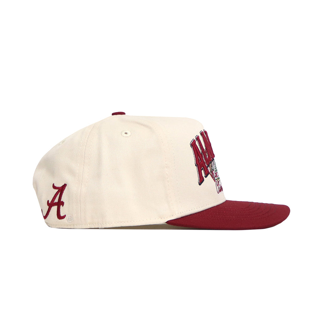 The Alabama Stadium Hat by No Rivals is a cream baseball cap with a maroon brim, maroon A side embroidery, partial Alabama graphics on the front, and a structured snapback design made from quality cotton for stylish comfort.
