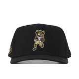 Introducing the Colorado Football Hat - Black by No Rivals. This black hat showcases an embroidered cartoon buffalo mascot holding a football on the front, outfitted in a gold and white uniform. A small gold embroidered logo accents the left side, while a classic snap back closure completes the look—making it the perfect gameday accessory for any fan.