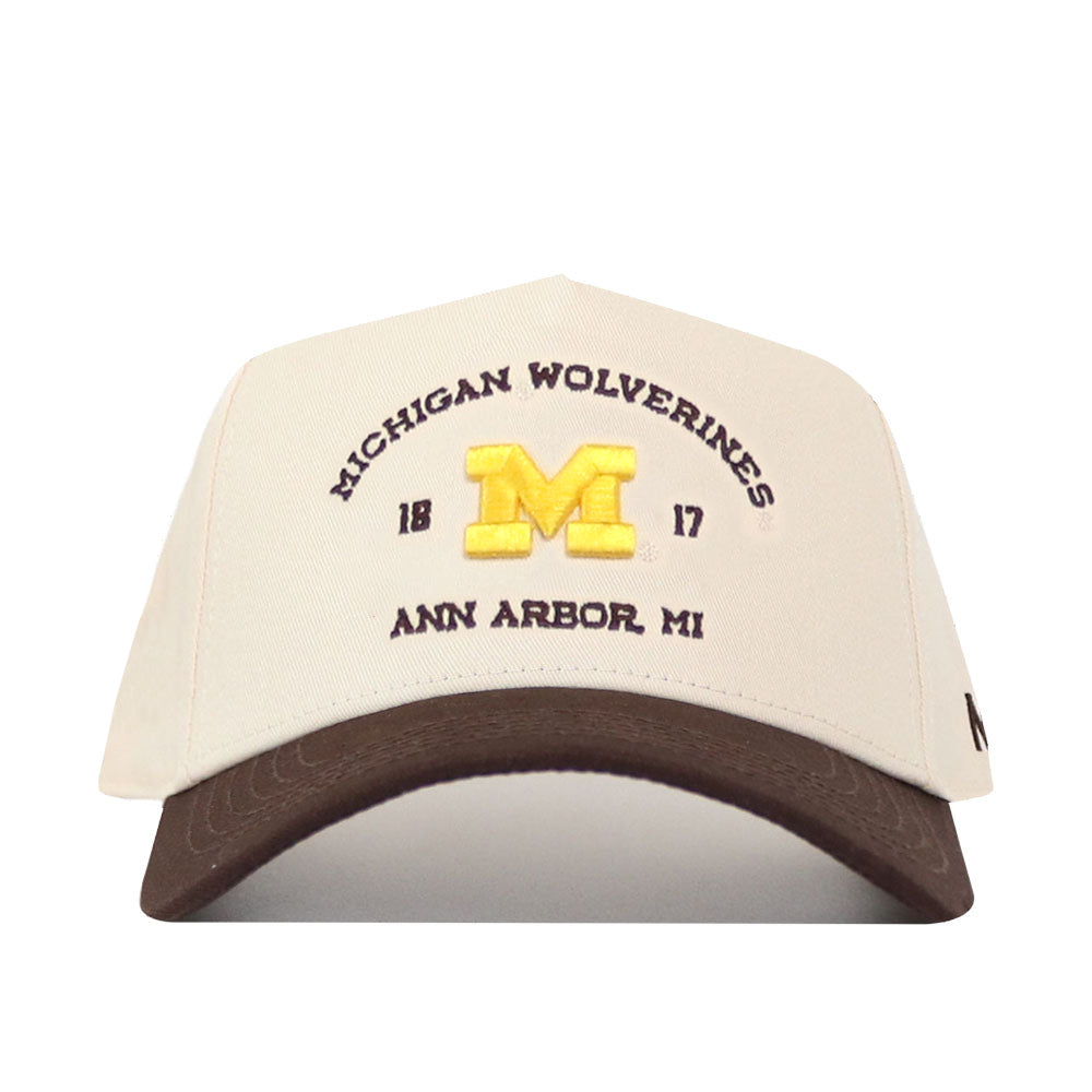 The No Rivals Michigan Wolverines Outlaw Hat - Classic showcases a cream and brown design with a prominent, embroidered yellow “M” logo on the front, along with “MICHIGAN WOLVERINES,” “18 17,” and “ANN ARBOR, MI” stitched detailing. Finished with a classic snap back closure for an ideal gameday fit.