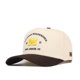Elevate your gameday fit with the Michigan Wolverines Outlaw Hat - Classic by No Rivals. This beige and brown snapback features “Michigan Wolverines” and “Ann Arbor, MI” embroidered on the front, a bold yellow M, the numbers 18 and 17, and an eye-catching embroidered logo.