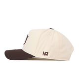 A side view of the Auburn Espresso Hat by No Rivals, featuring a cream crown with a brown brim. This stylish snapback has “NR” embroidered in brown near the back, making it an ideal gameday fit for any fan.