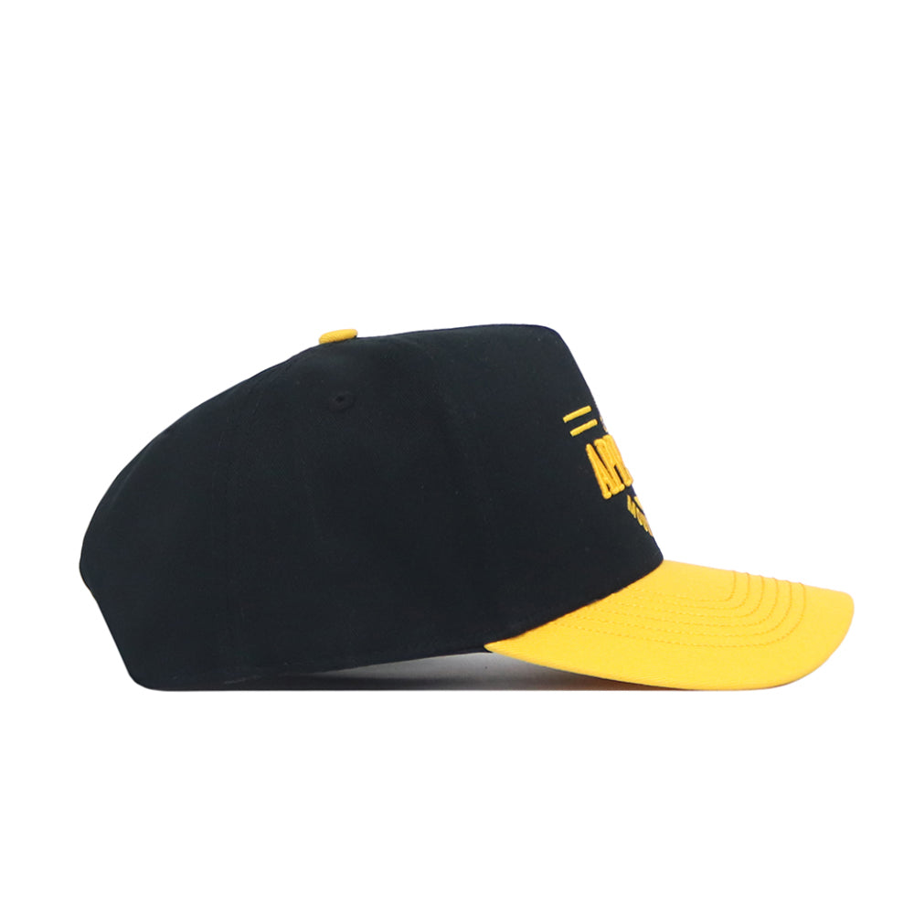 The No Rivals App State Tailgate Hat - 2 is a black snapback with a curved yellow brim, side view, featuring embroidered logos and yellow front text—ideal for upgrading your gameday look.