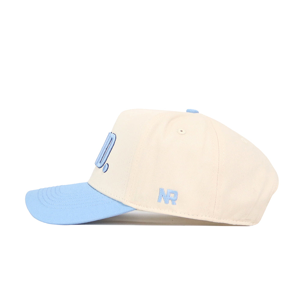 The No Rivals GTHD Hat is a beige snapback with a light blue brim and button, featuring officially licensed blue embroidered NR letters on the side.