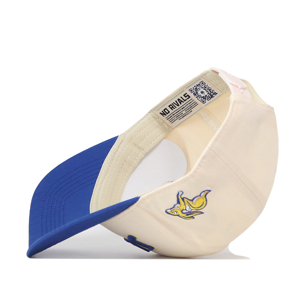 A cream and blue snapback baseball cap from No Rivals, called the Right Side Up Jacks Hat - Classic - South Dakota State Jackrabbits, is pictured upside down to reveal a yellow jackrabbit logo on the side and a NO RIVALS label inside the adjustable band.