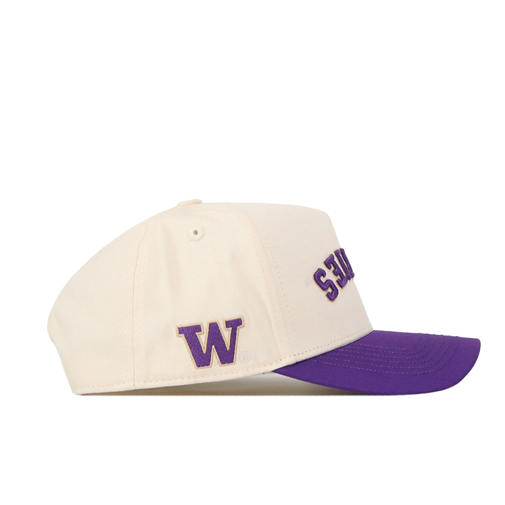 Show your Huskies pride in classic style with the Washington Huskies Upside Down Huskies Hat - Classic by No Rivals. This cream baseball cap features a bold purple brim, a purple “W” on the side, and partially visible purple text on the front for standout school spirit. Its comfortable snapback design provides an adjustable fit for all-day comfort.