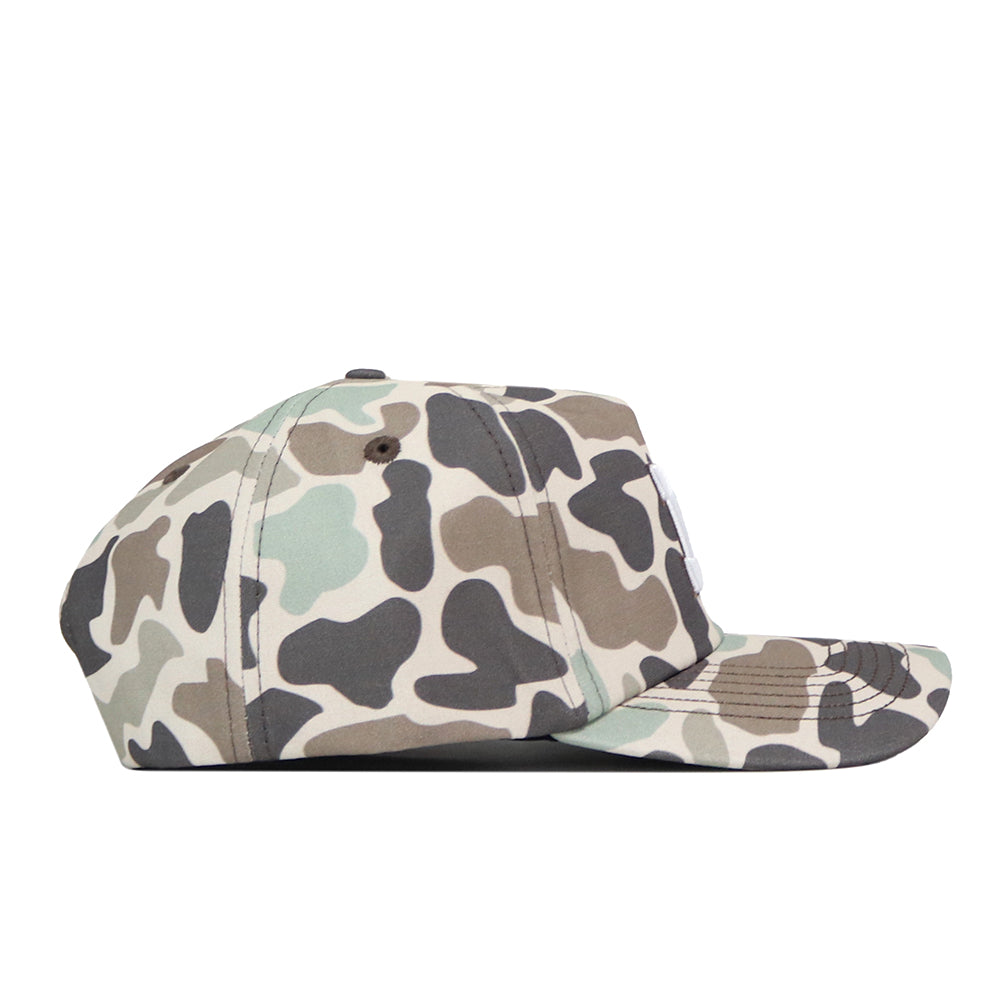 A side view of the Michigan Wolverines Huntsman Hat by No Rivals showcases its green, brown, and beige camouflage pattern. This snapback cap features a flat brim, visible stitching along the seams, and is finished with an embroidered logo—perfect for your next gameday fit.