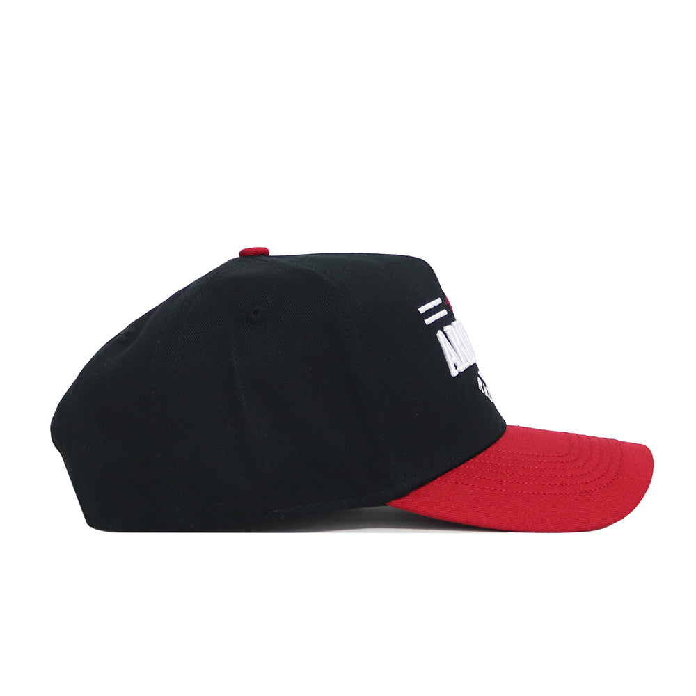 The No Rivals Arkansas Tailgate Hat is a black snapback with a red brim, shown in side profile. Crafted from high-quality cotton, it features a structured fit, partial white embroidered text on the front, and white/red stripes above.