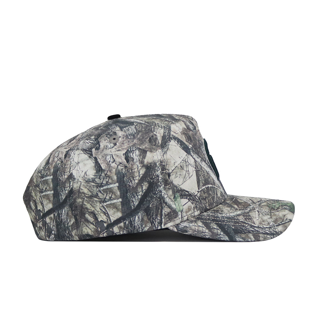 The Michigan State Outland Hat by No Rivals is a flat-brim baseball cap with a camouflage pattern in green, brown, and gray, crafted from high-quality cotton for lasting comfort and designed to blend with outdoor environments.