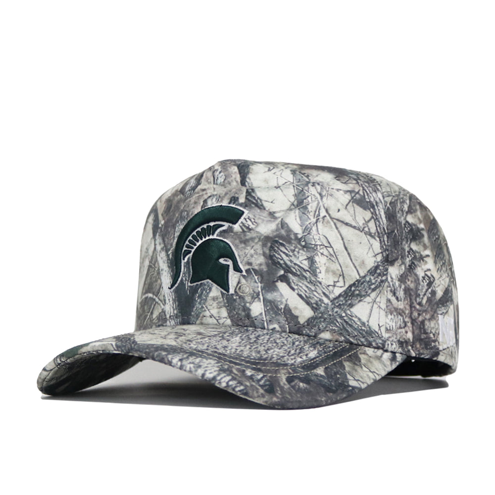The No Rivals Michigan State Outland Hat, a structured camouflage baseball cap with a green Spartan helmet logo on the front, representing Michigan State University, is displayed on a plain white background.