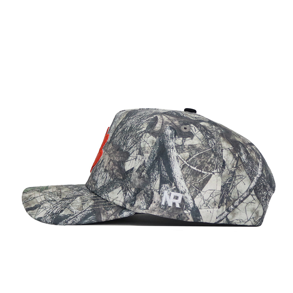 A side view of the Clemson Outland Hat by No Rivals, a high quality cotton snapback with a camouflage pattern, red front logo, and white "NR" initials embroidered on the side.