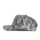 A side view of the Clemson Outland Hat by No Rivals, a high quality cotton snapback with a camouflage pattern, red front logo, and white "NR" initials embroidered on the side.