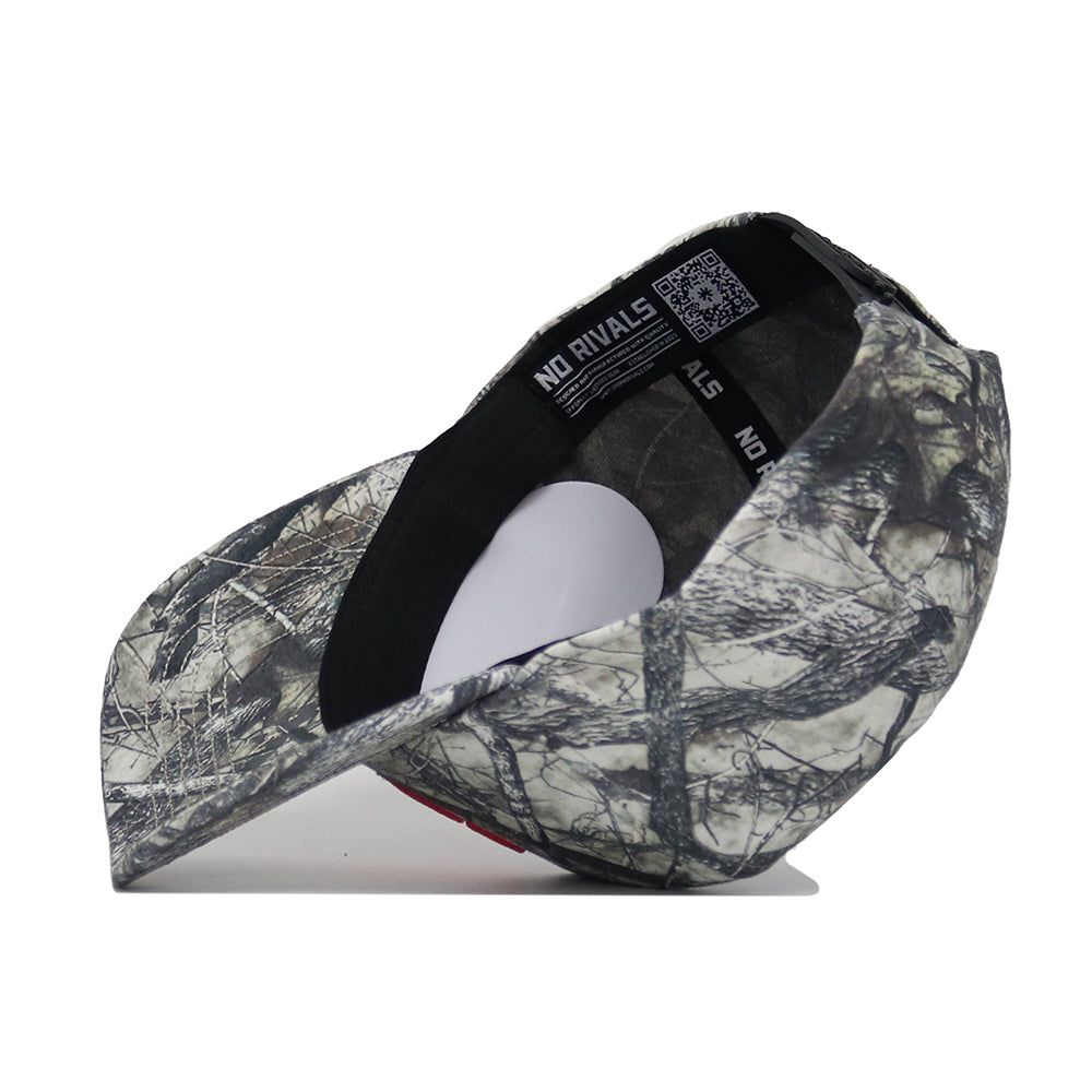 The Clemson Outland Hat by No Rivals, a high-quality cotton snap back with camouflage pattern, is pictured upside down on a white surface, showing its black trim, inner band with QR code, and white label.