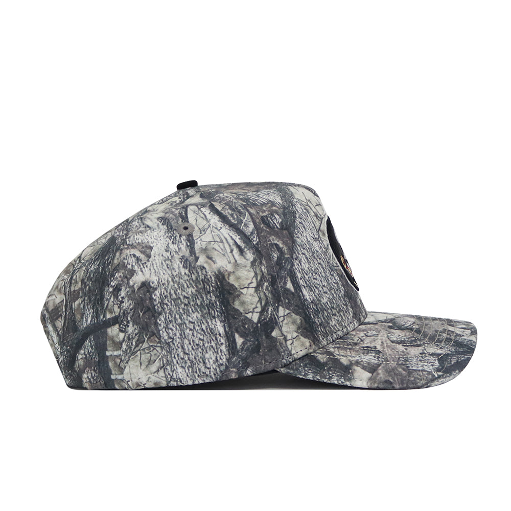 A side view of the No Rivals Florida State Outland Hat, a structured snapback with gray and black tree bark camo, made from high-quality cotton, shown against a plain white background.