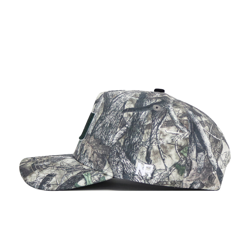 A side view of the University of Miami Outland Hat by No Rivals, a snapback featuring a green, brown, and beige camouflage pattern in high-quality cotton for a structured fit that blends into outdoor settings.