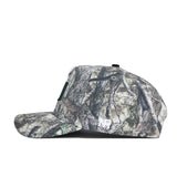 A side view of the University of Miami Outland Hat by No Rivals, a snapback featuring a green, brown, and beige camouflage pattern in high-quality cotton for a structured fit that blends into outdoor settings.