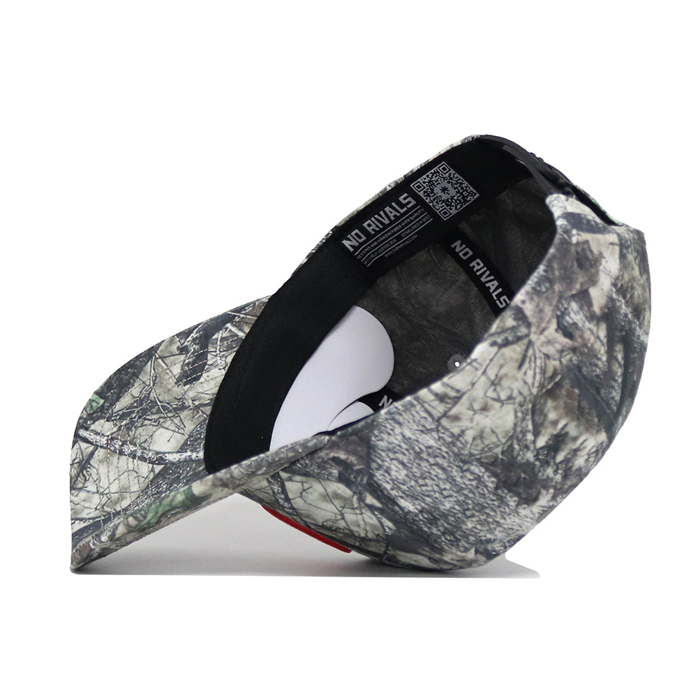 The No Rivals University of Miami Outland Hat is displayed upside down, showing interior labels and stitching. Its exterior and bill feature a woodland camo pattern on high-quality cotton for a comfortable, structured fit.
