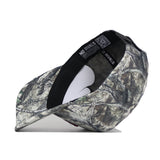 A Virginia Tech Outland Hat by No Rivals, featuring a camouflage pattern, is displayed on its side to reveal “NO RIVALS” along the inner band and a QR code under the brim, set against a plain white background.