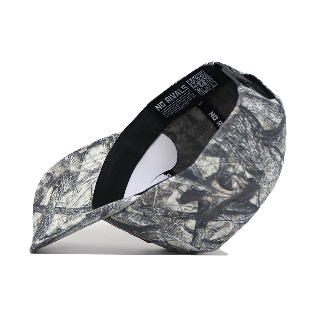 The Oklahoma Outland Hat by No Rivals is a high-quality cotton baseball cap with a gray and black forest camouflage pattern, curved brim, and an inside label that reads NO RIVALS.