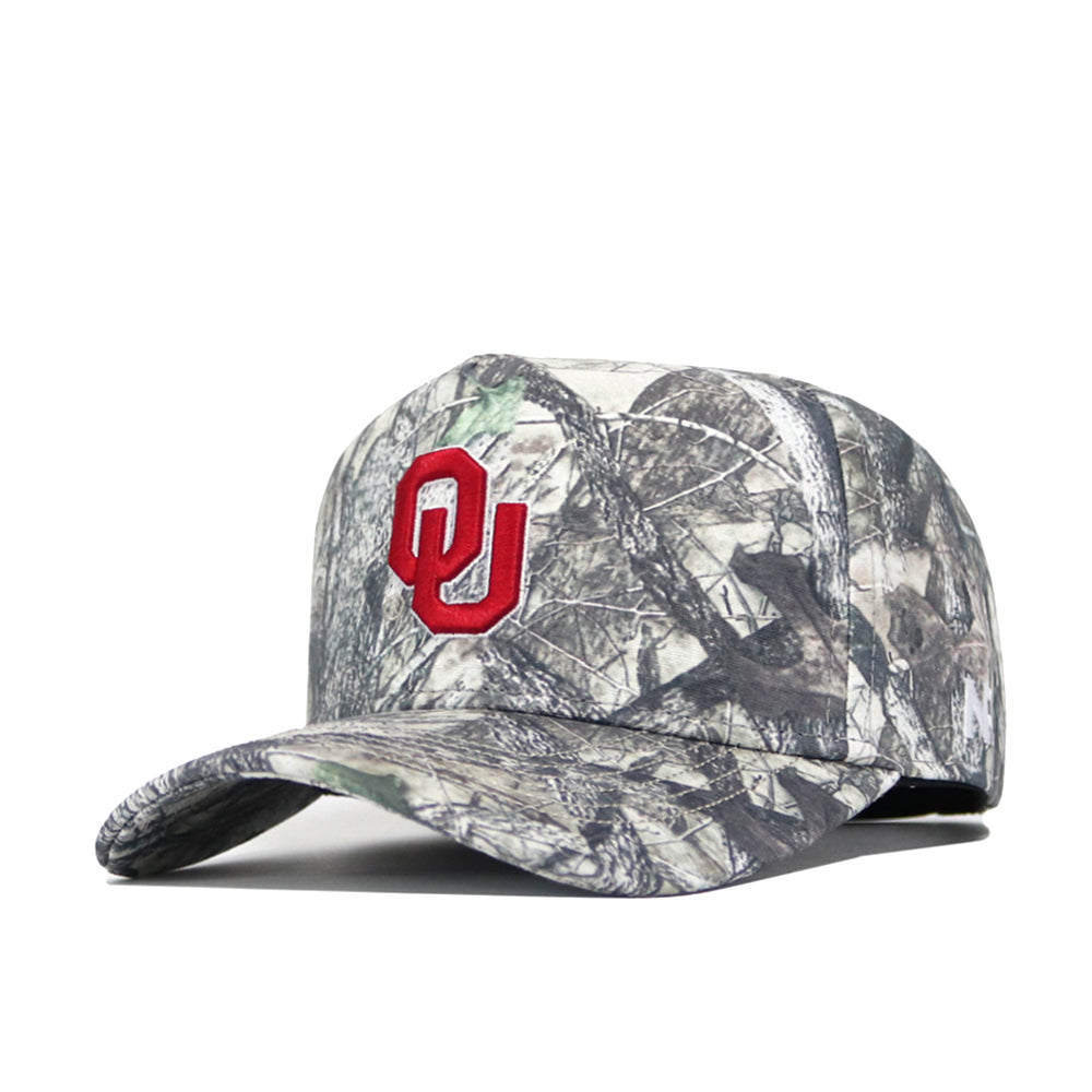 The No Rivals Oklahoma Outland Hat is a structured, camouflage cotton cap with a red OU logo embroidered on the front, representing the University of Oklahoma.