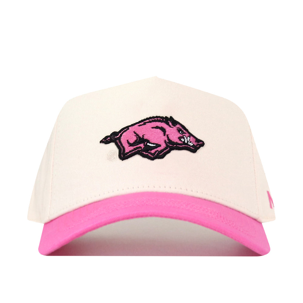 Introducing the Arkansas Pink Out Hat by No Rivals—a white snapback hat with a pink brim, showcasing an officially licensed pink and black wild boar logo on the front. A portion of proceeds supports the Breast Cancer Foundation.