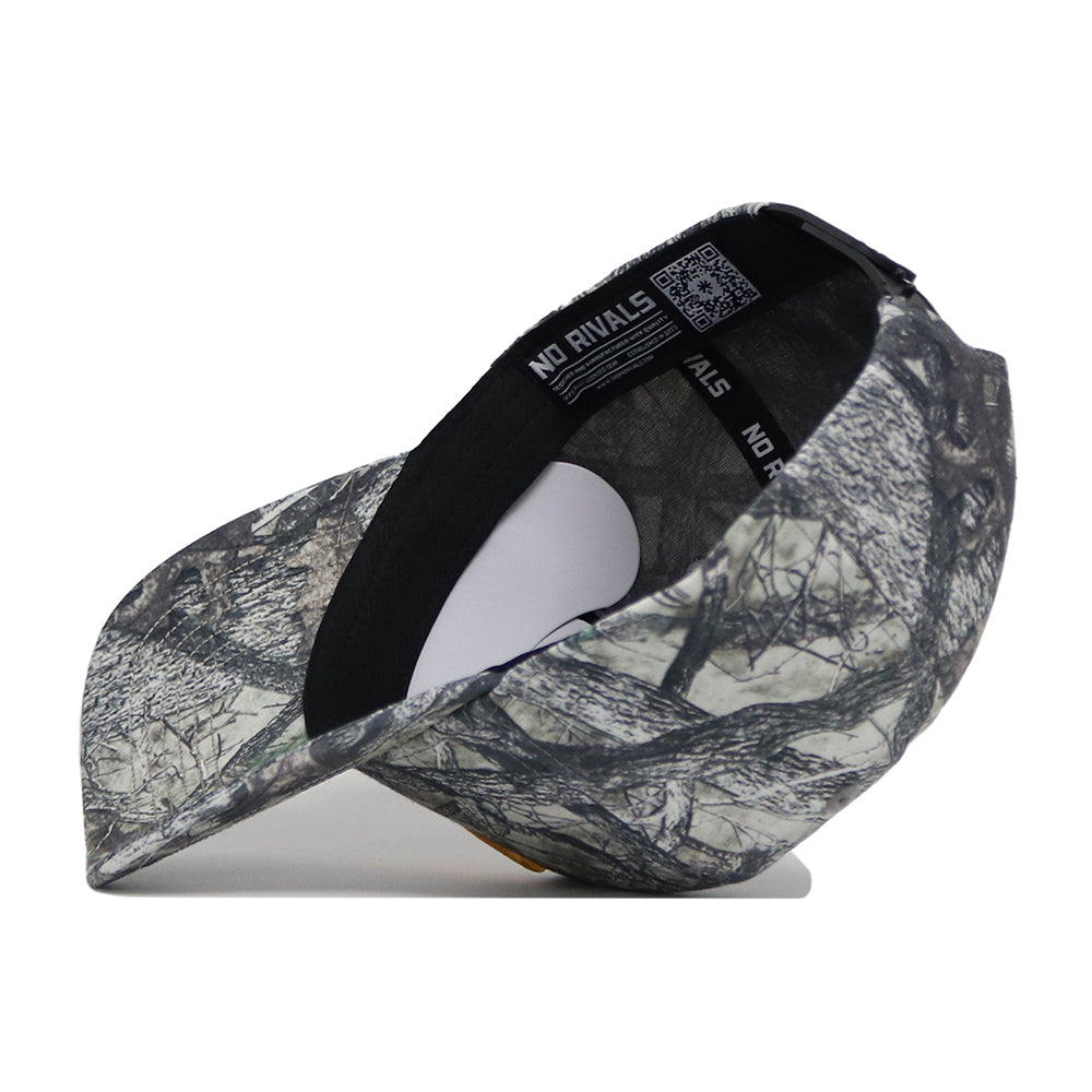 The West Virginia Outland Hat by No Rivals is a camouflage snapback, shown on its side to display black inner bands with “NO RIVALS” in white. Made from high-quality cotton, it features a structured fit against a plain white background.