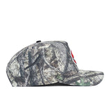 Side view of the No Rivals Western Kentucky Outland Hat, a structured fit cap in green, brown, and gray camo cotton with a partially visible red and white embroidered patch on the front.