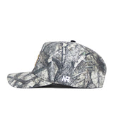 Side view of the UCF Outland Hat by No Rivals, featuring gray and white camo, a small white embroidered logo near the back, a flat matching bill, and a structured snapback fit for lasting shape and style.