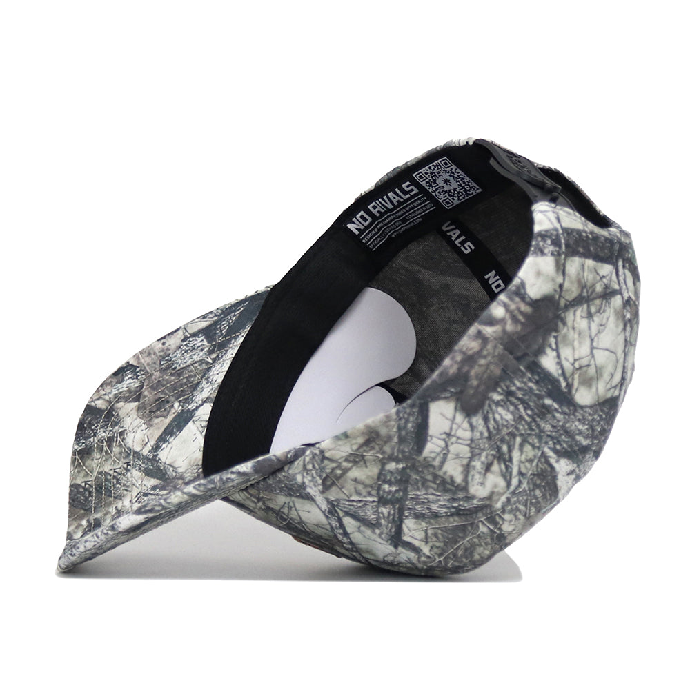 A UCF Outland Hat by No Rivals, shown on its side to display the camouflage pattern, inside lining, QR code label, and “NO RIVALS” printed on the inner band.
