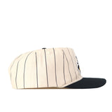 The Wichita State Pinstripe Hat by No Rivals features a cream snapback with black vertical pinstripes, a black brim, and high-quality cotton, shown in profile against a white background.