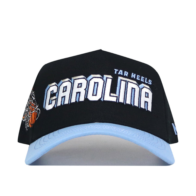 The North Carolina (UNC) Courtside Hat is a black and light blue snapback featuring "CAROLINA" in bold white letters with "TAR HEELS" in smaller blue text above, crafted from high quality cotton for a structured fit.
