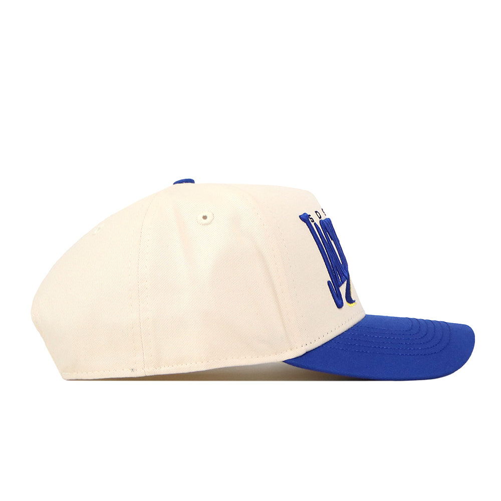 The No Rivals South Dakota State Jackrabbits Stride Hat features a cream-colored crown with a blue brim and blue embroidered logos on the front, shown in profile view with the brim facing right—perfect for completing your gameday fit.