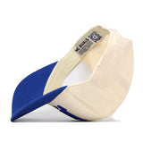 The South Dakota State Jackrabbits Stride Hat by No Rivals is shown flipped upside down, revealing its blue brim, cream-colored crown, and inner tags featuring a QR code and NO RIVALS text—complete with embroidered logos for the perfect gameday fit.