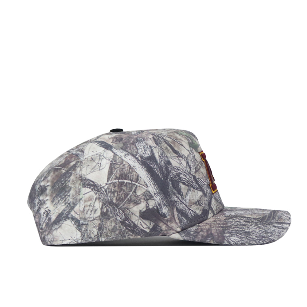 The No Rivals Minnesota Gopher Outland Hat is pictured from the side, showcasing a camouflage pattern in abstract gray and green tones. The front displays a partially visible red and yellow embroidered logo.