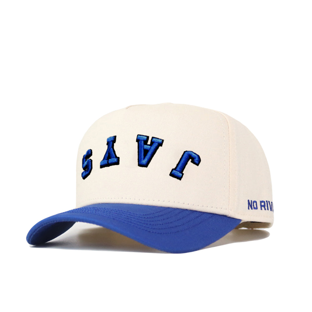 The Upside Down JAYS Hat by No Rivals features cream cotton-canvas, a blue curved brim, "JAYS" embroidered upside down in bold blue, and "NO RIVAL" stitched on the side—Creighton’s classic colors on a snapback style.