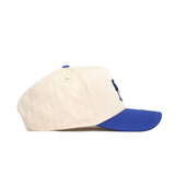 The No Rivals Creighton Logo Patch Hat is a beige cotton blend snapback with a curved royal blue brim, shown from the side against a white background.