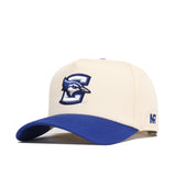 The No Rivals Creighton Logo Patch Hat is a cream cotton blend snapback with a blue brim, featuring 3D embroidery of a stylized C, a blue jay logo on the front, and NF lettering on the side.