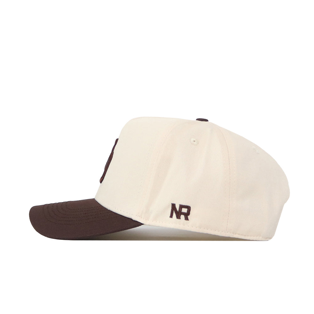 The Oregon Espresso Hat by No Rivals is a cream snapback baseball cap with a brown brim. It features "NR" embroidered in brown thread near the back for a subtle brand logo—ideal for your gameday look.
