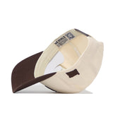 The Oregon Espresso Hat by No Rivals is a cream and brown snapback cap shown from the underside, featuring an inside label with "NO RIVALS" text and a QR code near the sweatband, a curved brown brim, and an adjustable strap.