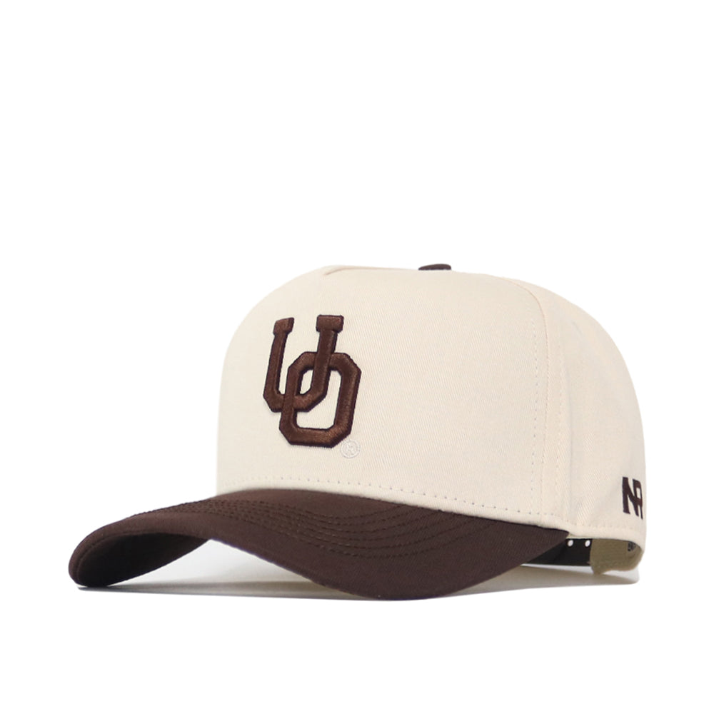The No Rivals Oregon Espresso Hat is a beige baseball cap with a brown curved brim, raised brown "UD" embroidery on the front and "NP" on the side, plus a snapback closure—perfect for your gameday look. Displayed on a white background.