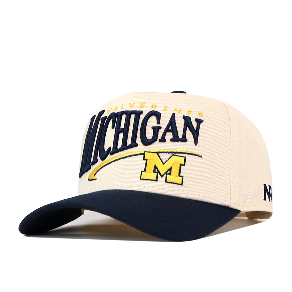 Show your school spirit with the Michigan Wolverines Stride Hat by No Rivals. This officially licensed cream and navy snapback cap features “Michigan” in bold lettering, “Wolverines” above, and a yellow embroidered M logo below—perfect for any dedicated fan.