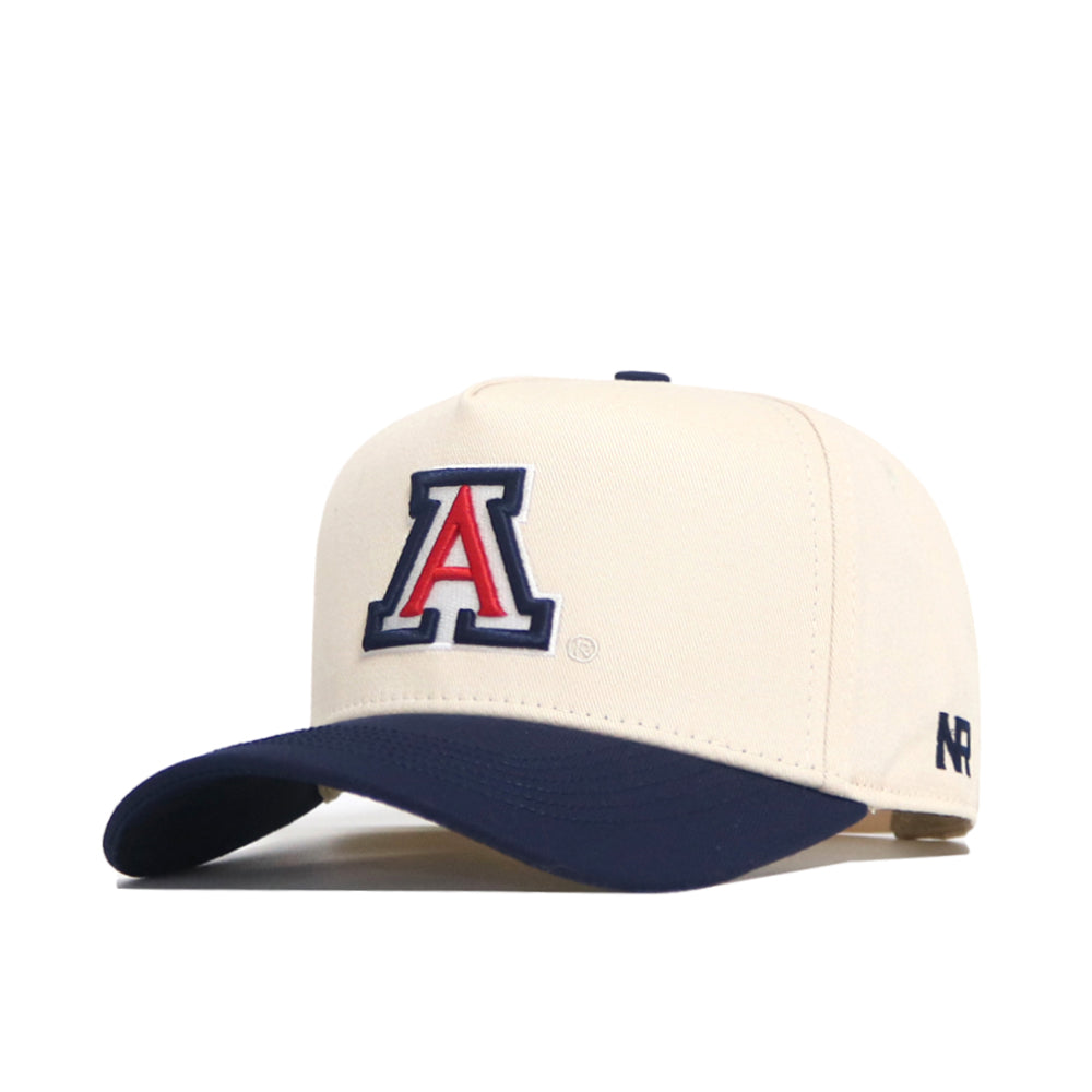 The No Rivals Arizona Logo Patch Hat is cream with a navy brim, showcasing a bold 3D red, white, and blue "A" logo on the front and "AR" embroidered on the side.