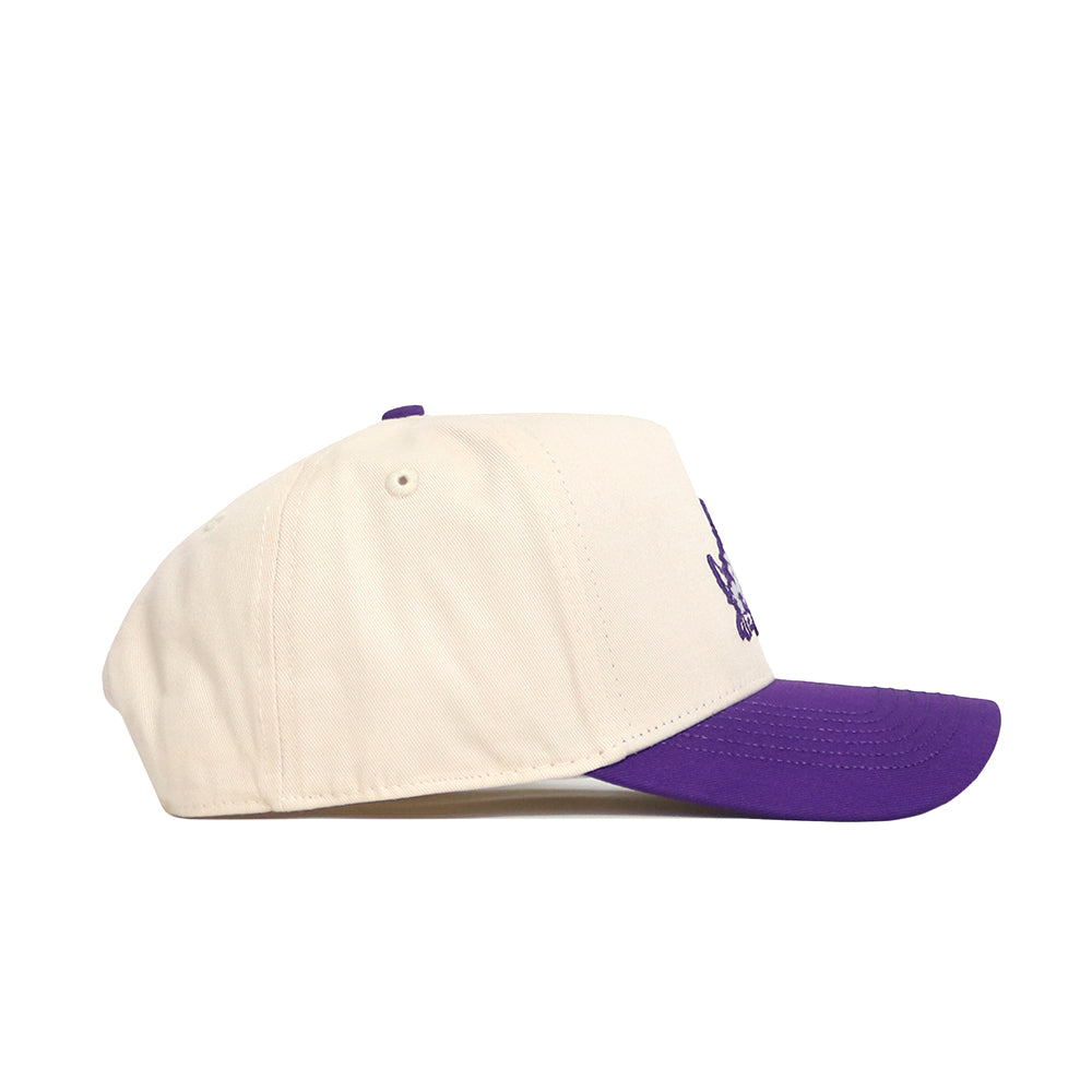 The No Rivals TCU Logo Patch Hat is cream-colored with a purple brim and patch embroidery, shown from the side on a white background.
