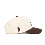 The No Rivals Alabama Espresso Hat features a cream color, structured snapback fit, brown bill, and a small brown Alabama silhouette on the side, all crafted from high-quality cotton.
