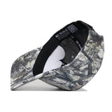 The Penn State Outland Hat by No Rivals is shown upside down on a white background, revealing its camouflage pattern, interior label, black sweatband, and a white crown insert. Made from high-quality cotton.