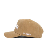 The North Carolina Rustic Hat by No Rivals is a tan cotton canvas cap with a curved brim, white "NO RIVALS" embroidered on the side, and large white front text. This structured hat blends comfort and standout style.