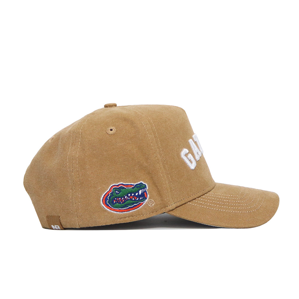 The No Rivals Florida Rustic Hat is a brown cotton canvas snapback with a structured fit, featuring "GATORS" stitched in white on the front and an embroidered alligator logo on the side. The hat is shown from the side against a plain white background.